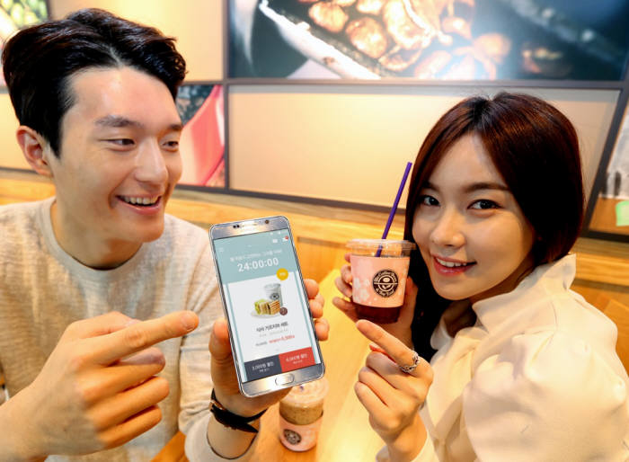 SK텔레콤 모델들이 서울 중구에 위치한 `커피빈`에서 `T 라이프`의 커피 할인 혜택을 체험하는 모습
