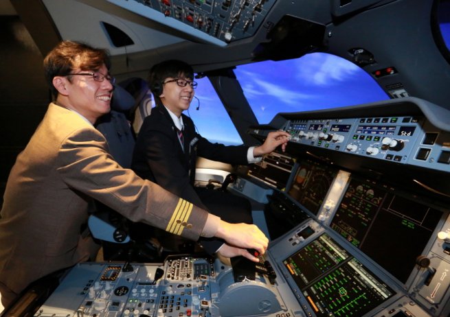 27일 서울 강서구 아시아나타운 운항훈련동에서 진행된 'A350 시뮬레이터 체험 프로그램'에서 신서중학교 이택현 군이 아시아나항공 황남식 기장에게 시뮬레이터 조작법 교육을 받고 있다. 