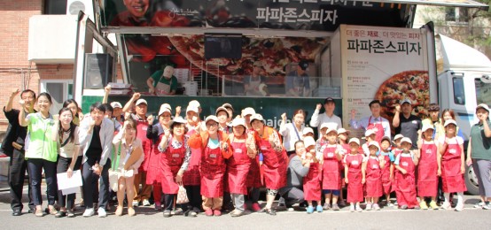 한국파파존스 직원들과 우면동 지역 주민들이 2일 우면사회복지회관 앞에서 '맛있는 나눔 캠페인' 활동 진행하며 기념사진 촬영을 하고 있다. 사진=한국파파존스 제공