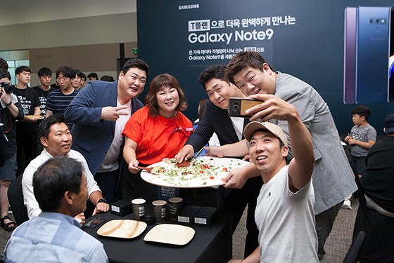 방송인 김준현 씨, 김민경 씨, 문세윤 씨, 유민상 씨(첫번째 사진 왼쪽부터)가 T플랜의 넉넉한 데이터를 상징하는 지름 60cm의 대형 피자를 고객들에게 나눠주고 있는 모습