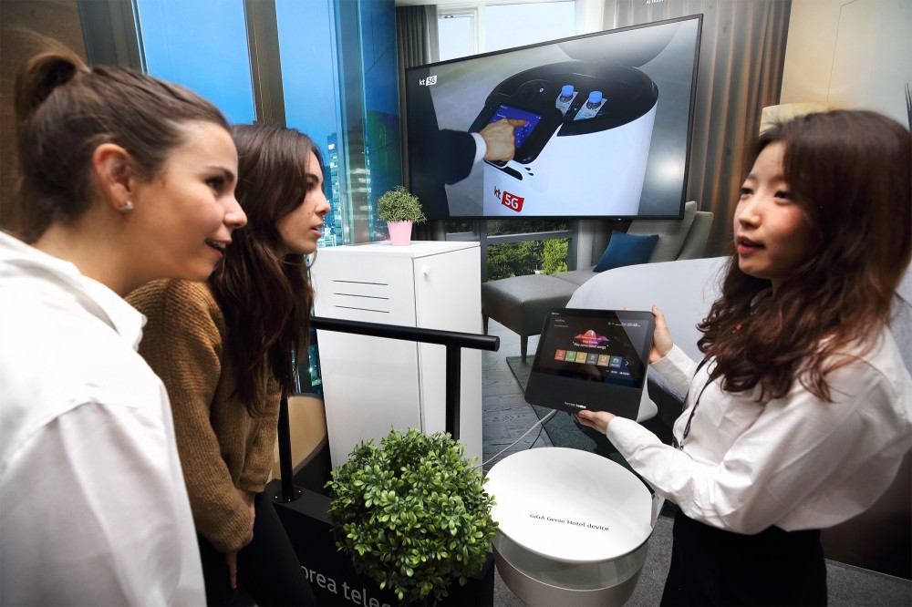 25일(현지시간) KT 전시관 내 5G AI 호텔 로봇 존에서 관람객이 AI 호텔 로봇 서비스를 체험하고 있다 [사진=KT]