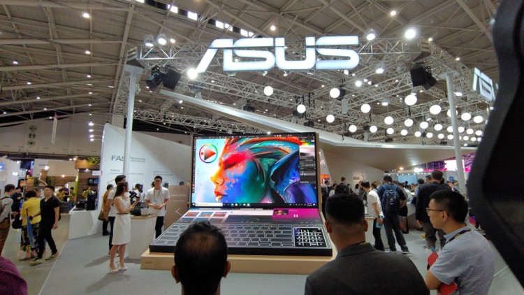 에이수스 직원들이 젠 북 듀오(ZenBook DUO)를 형상화한 대형 모형 앞에서 제품의 특장점을 설명하고 있다.