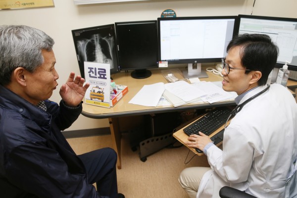서울아산병원 호흡기내과 이세원 교수가 택시기사의 폐기능 검사와 흉부 X-선 검사를 확인하며 진료상담을 하고 있다.