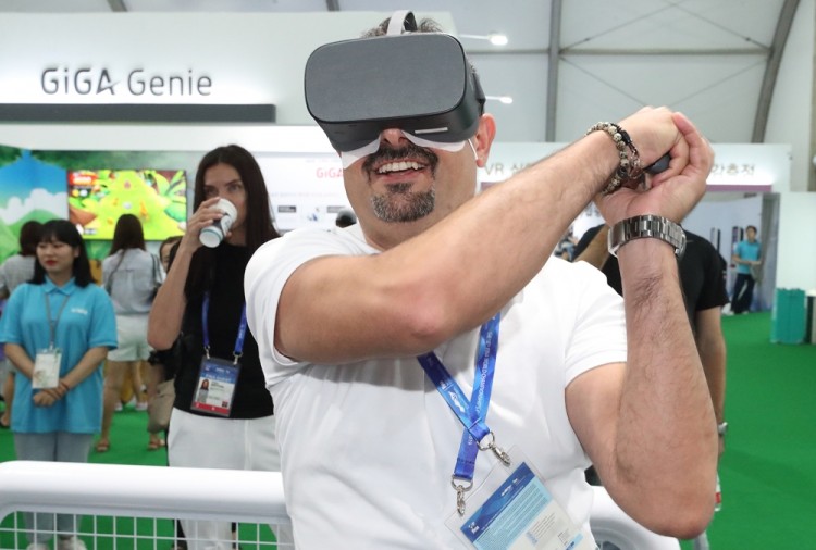 광주세계수영선수권대회에 마련된 KT 5G ICT 체험관에 방문한 글로벌 관람객들이 실감형 VR 서비스를 체험하고 있다 [사진=KT]