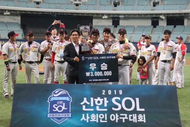신한은행이 개최한 신한 쏠(SOL) 사회인 야구대회가 지난 1일 서울 고척 돔 아구장에서 결승전을 끝으로 마무리됐다. 신한은행 관계자와 우승팀 '루디프로젝트' 선수들이 기념 촬영을 하고 있다.