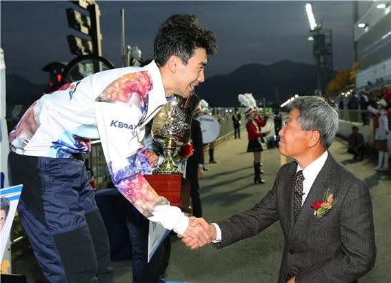 2018년 쿠리하라배 특별 경정에 참석한 쿠리하라 코이치로 선생이 우승을 차지한 조성인 선수에게 트로피를 수여하고 악수하고 있다.
