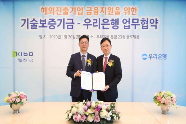 우리은행 서영호 글로벌그룹장(오른쪽)과 김영춘 기술보증기금 이사가 해외 진출기업 금융지원을 위한 양 기관의 업무협약을 맺은 후 기념 촬영을 하고 있다.