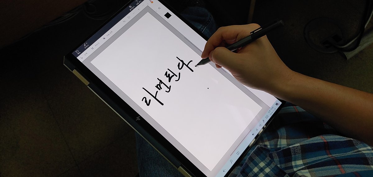 태블릿 모드에서 펜으로 붓글씨를 연습하고 있다.