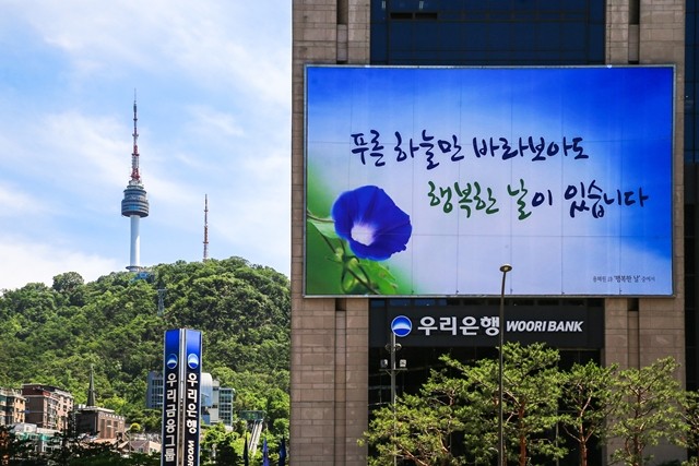 우리은행이 서울 중구 본점 외벽에 코로나19 극복 염원을 담은 대형 글판을 게시하고 있다.