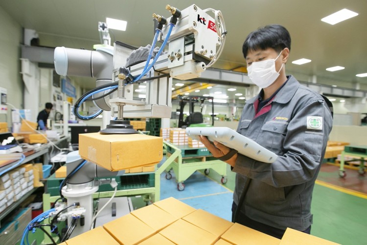 충북 제천에 있는 박원 공장에서 생산직 근로자가 KT 5G 스마트팩토리 코봇과 함께 작업하고 있다. [사진=KT]