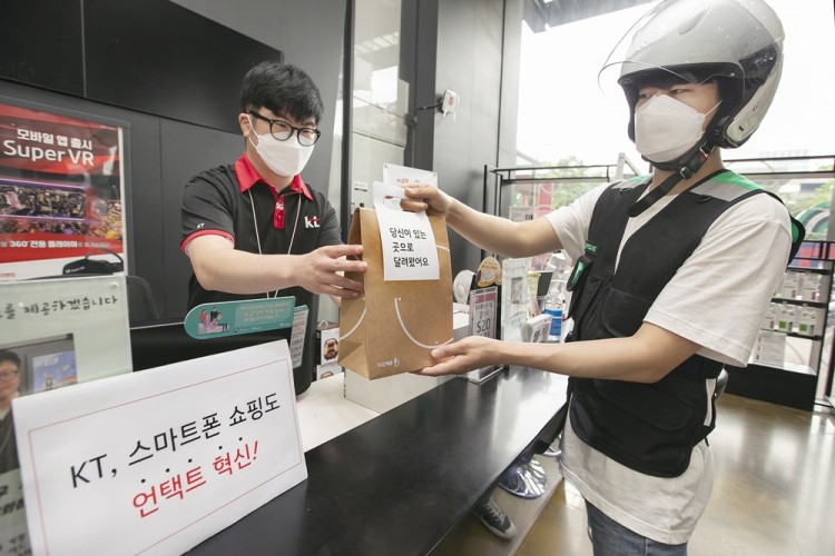 KT 대리점 직원이 부릉 라이더에게 ‘1시간배송’ 서비스를 통한 핸드폰 배송을 요청하고 있다. [사진=KT]