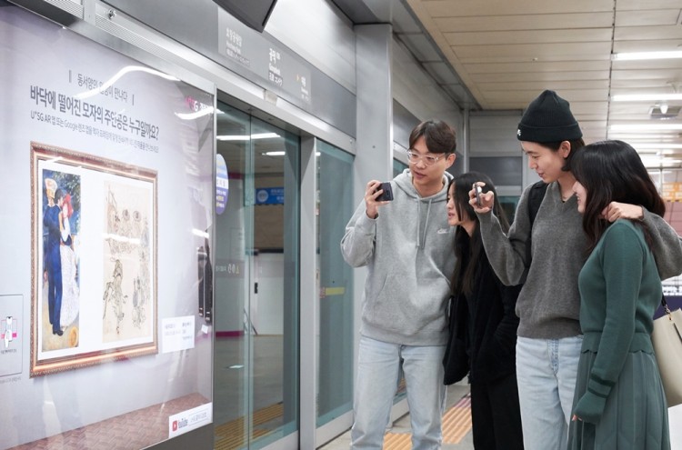 서울 지하철 6호선 공덕역에 마련된 ’U+5G 갤러리’ 방문객들이 ‘U+AR’ 앱으로 작품을 감상하고 있다. [사진=LG유플러스]