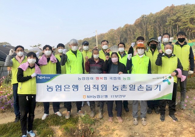 NH농협은행 정보보안부문 김유경 부행장(사진왼쪽 5번째)과 직원들이 농촌일손돕기를 실시하며 단체사진을 찍고 있다. 