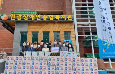 하이트진로가 전달한 희망나눔박스 앞에서 김선기(앞줄 오른쪽 3번째) 원광장애인 복지관 관장을 포함한 직원들이 기념촬영을 진행하고 있다.
