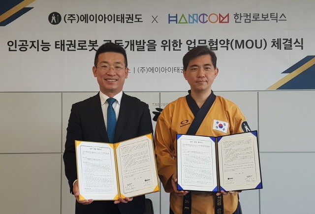 전동욱 한컴로보틱스 대표(왼쪽)와 최중구 에이아이태권도 대표가 업무협약을 맺고 기념 촬영을 하고 있다.