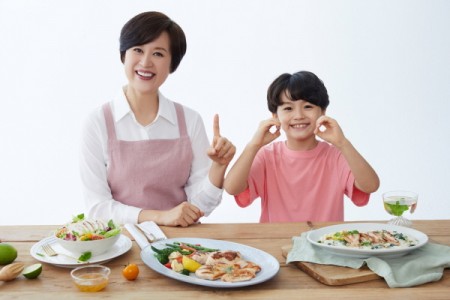 CJ제일제당 'The더건강한 닭가슴살'로 만든 요리와 함께 브랜드 모델 박미선과 어린이 모델이 포즈를 취하고 있다.