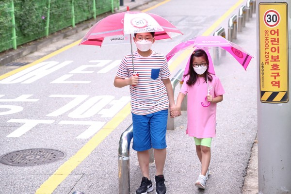  LG디스플레이가 어린이들의 안전을 위해 빗길 교통사고 예방 효과가 높은 '투명 안전 우산' 1만 6,000개를 무료로 배포한다. 어린이들이 LG디스플레이가 준비한 '투명 안전 우산'을 쓰고 가는 모습.