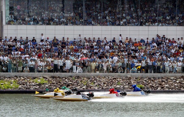경정 시작 원년인 2002년 미사리경정장에서 수많은 관중이 지켜보는 가운데 경주가 진행되고 있다.