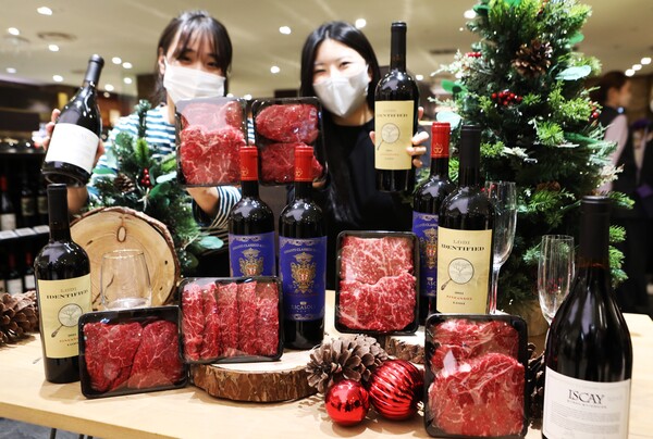 롯데백화점 본점 와인 매장에서 모델 2명이 '축산&와인' 페스티벌 상품을 홍보하고 있다.