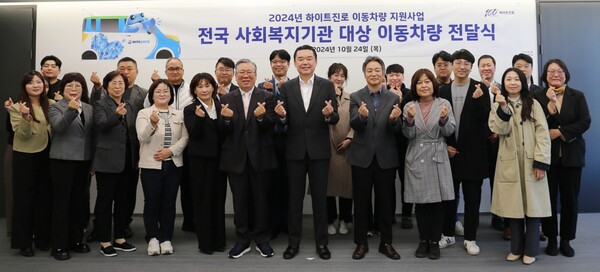 On the 24th, a mobile vehicle delivery ceremony was held with Hite Jinro CEO Kim In-gyu (fourth from the right in the front row) and representatives and officials of social welfare organizations in attendance.